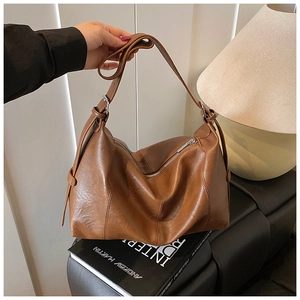 Detail view of large brown hobo bag with vintage leather texture and adjustable strap