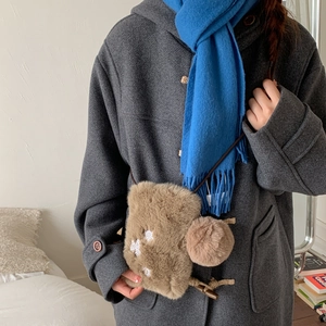 Détail d'un sac d'hiver en peluche avec broderie flocon de neige et pompon décoratif