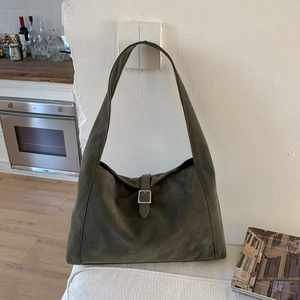 Detail of olive green suede hobo bag with silver buckle and wide shoulder strap