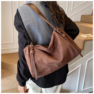 Brown faux suede shoulder bag with adjustable leather strap and gold metal buckles