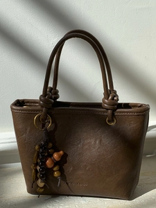 Borsa a secchiello vintage marrone in pelle con manico a nodo e dettaglio charm