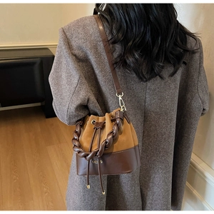 Brown bicolor bucket bag with woven handle and CAEN D gold stamp details