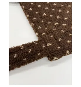 Detail view of reinforced stitching on brown plush tote bag with light floral pattern