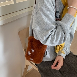 Détail du sac bandoulière en peluche marron avec broderie de flocons de neige blancs