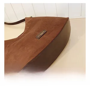 Detail shot of brown suede and smooth leather stitching on a retro bucket bag