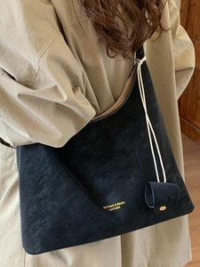 Minimalist black leather tote bag with white contrast stitching and large capacity for daily use