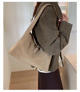 Brown suede tote bag with large capacity shown on shoulder in minimalist interior