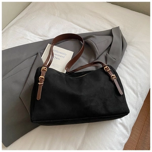 Detail of black suede fabric and brown leather strap with golden metal buckle