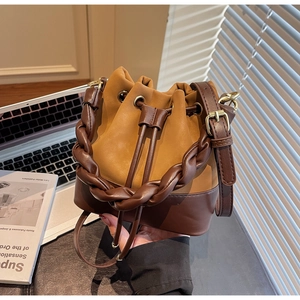 Close-up of contrast bucket bag with braided leather handle and drawstring closure