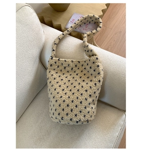 Detail of floral beige fleece tote bag with blue patterns on a soft white sofa