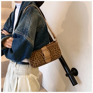 Detail shot of leopard print shoulder bag with gold metal buckle and brown leather strap