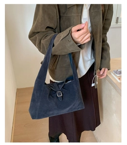 Detailed view of matte suede hobo bag with metal buckle on a shoulder-length strap