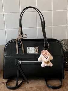 Elegant black leather handbag with silver hardware and cute plush puppy charm