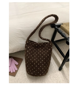 Detail of soft brown plush tote bag with light polka dots on a cozy bedroom background