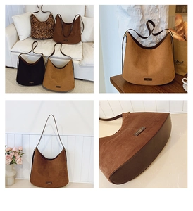 Detailed view of large crescent bucket bags in matte suede with reinforced leather base
