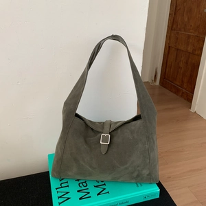 Detail view of the vintage olive green suede hobo bag with a silver buckle and wide strap