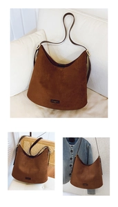 Macro detail of dark brown suede hobo tote showing fine texture and golden metal buckle