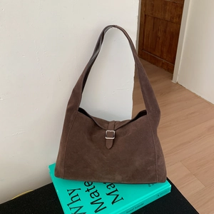 Detailed texture of dark brown suede crescent hobo bag with silver buckle strap