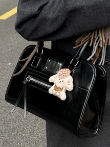 Chic black glossy leather handbag with tassels and cute puppy charm for 2025 autumn fashion