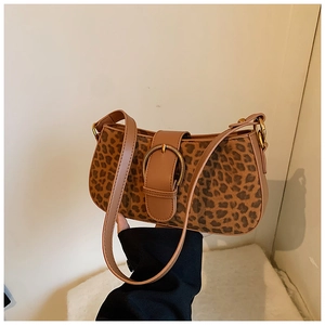 Detail of leopard print underarm bag with gold ring buckle and brown leather strap
