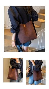 Detail view of the deep brown suede bucket bag with its elegant golden metal buckle closure
