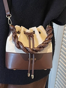 Minimalist beige suede and brown leather bucket bag with woven handle and shoulder strap
