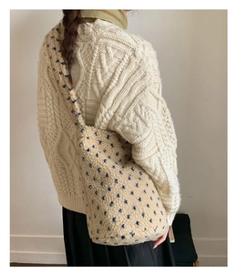 Back view of a white fleece tote bag with blue star patterns worn by a model