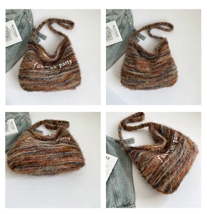 Dettaglio della borsa hobo in peluche a righe con ricamo di lettere bianche moda