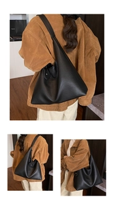 Detail of black pebbled leather Hobo bag featuring integrated wide shoulder strap design
