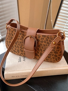 Chic leopard print crossbody bag with retro buckle on vintage book background
