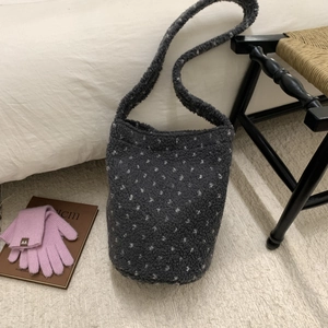 Detail of grey polka dot fleece bucket bag showing soft texture and integrated strap