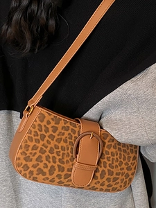 Brown leopard print shoulder bag with metallic buckle shown worn over a shoulder