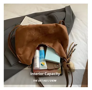 Detail of spacious interior of brown suede tote bag showing everyday essentials capacity