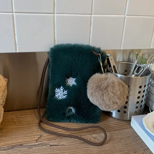 Détail du petit sac à bandoulière en fausse fourrure verte avec broderie flocon de neige