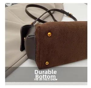Detail of durable bag bottom with golden metal studs and brown suede texture