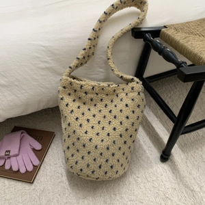 Detail view of plush lamb wool bucket bag with blue polka dots and soft fuzzy texture