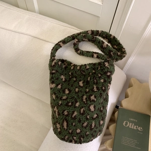 Gros plan d'un sac cabas en fausse fourrure léopard vert avec une texture moelleuse