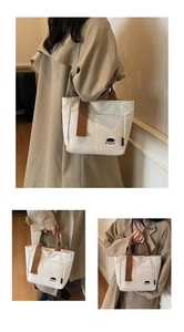 Vue détaillée du sac cabas en toile unie avec broderie cartoon et large bandoulière