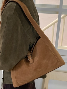 Vintage caramel brown suede crescent shoulder bag with adjustable metal buckle strap detail