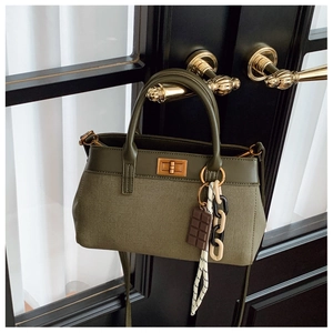 Olive green canvas and leather bucket bag with gold turn-lock and chocolate charm detail