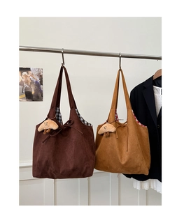 Détail des sacs fourre-tout en daim avec fermeture à cordon et breloque croissant