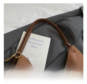 Close-up of brown suede tote bag with leather handle and leopard print plush charm detail
