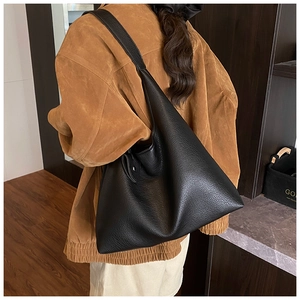 Close-up of black lychee grain leather hobo bag showing texture and slouchy silhouette