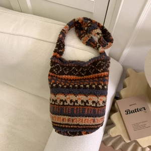 Détail d'un sac fourre-tout à motifs géométriques et texture douce sur un canapé