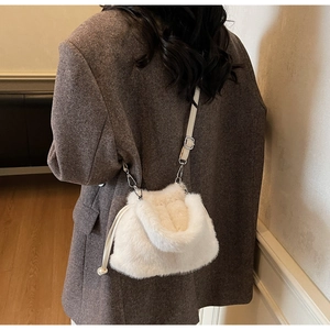 Détail du sac seau en peluche ivoire avec cordon de serrage et fine bandoulière réglable