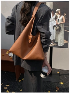 Brown litchi grain leather tote bag shown from back view in a stylish autumn street setting