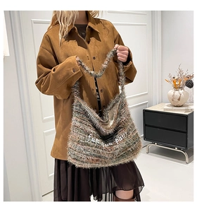 Dettaglio della borsa tote in peluche multicolore con ricamo bianco e frange