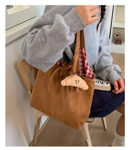 Détail du sac fourre-tout en velours avec pendentif croissant en peluche et doublure à carreaux
