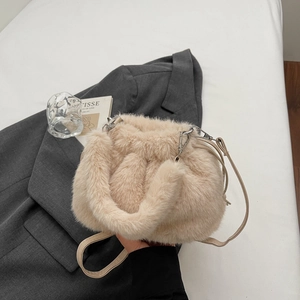 Détail du sac seau en peluche beige doux montrant la texture et les pièces argentées