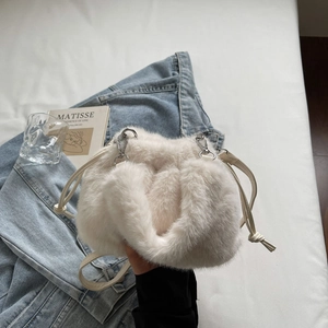 Détail du sac seau en fausse fourrure blanc cassé avec cordon et boucles argentées
